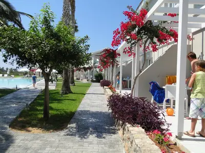 a child standing next to a sidewalk next to a building at Mon Repos Hotel in Ayia Napa