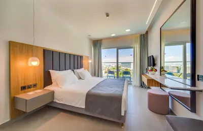 a bedroom with a large bed and a balcony at Napa Mermaid Hotel & Suites in Ayia Napa