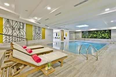 a swimming pool with a couch in front of it at Napa Mermaid Hotel & Suites in Ayia Napa