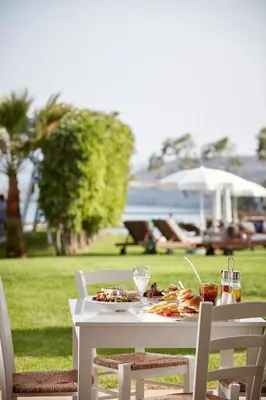 a white table with a plate of food on it at Grecian Park in Protaras