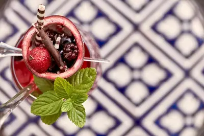 a drink with a strawberry and mint on a table at Grecian Park in Protaras