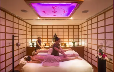 two women are laying on a bed in a room at Amathus Beach Hotel Limassol in Limassol