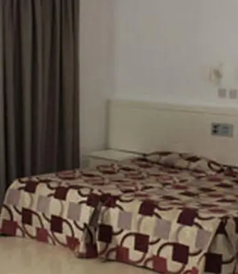 a bedroom with a bed with a brown and white blanket at Astreas Beach Hotel Apartments in Protaras