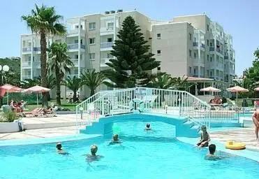 a swimming pool with people in the water at Astreas Beach Hotel Apartments in Protaras