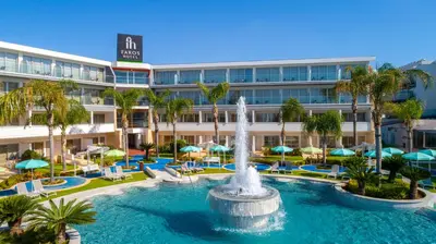 a pool with a fountain in front of a hotel at Faros Hotel Ayia Napa in Ayia Napa