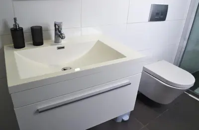 a white bathroom with a sink and a toilet at Chris House in Nicosia