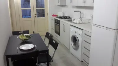a kitchen with a black table and a table and a kitchen with a refrigerator at Chris House in Nicosia