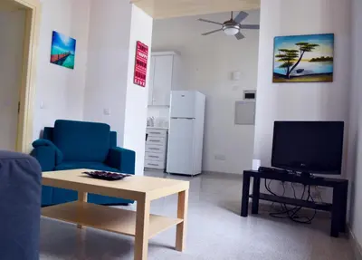 a living room with a blue chair and a tv at Chris House in Nicosia