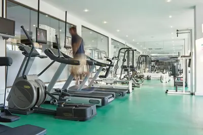 a gym with several treadmills and a man on a treadmill at Grecian Bay in Ayia Napa