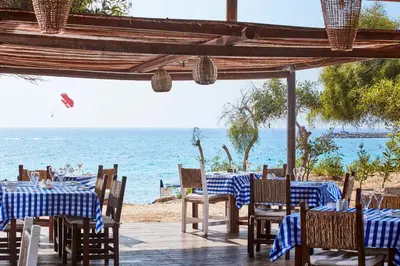 a restaurant with tables and chairs on the beach at Grecian Bay in Ayia Napa