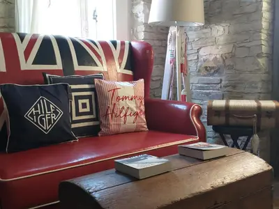 a living room with a red leather couch and a coffee table at Stratos ArtDeco House in Kalavasos