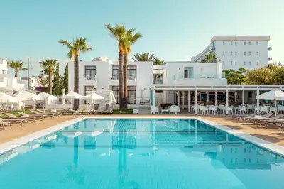 a swimming pool with a hotel in the background at Lantiana Napa Aparthotel in Ayia Napa