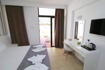a hotel room with a bed and a desk and a television at Lantiana Napa Aparthotel in Ayia Napa