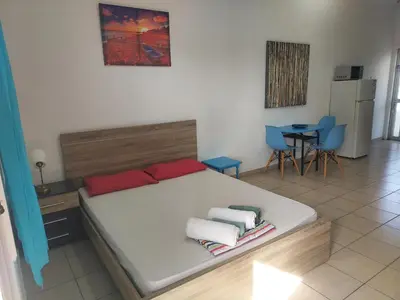 a bedroom with a bed and a table and chairs at Sea Apartments in Larnaka