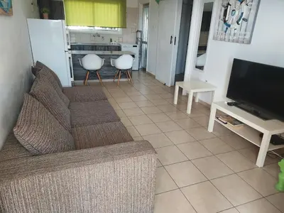 a living room with a couch and a television at Sea Apartments in Larnaka