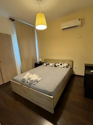 a bedroom with a bed with slippers on it at Sea Apartments in Larnaka