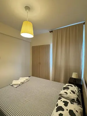 a bedroom with a bed with a black and white blanket at Sea Apartments in Larnaka