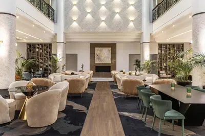 a hotel lobby with tables and chairs at Hilton Nicosia in Nicosia