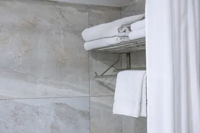 a bathroom with white towels and a shower at Livadhiotis City Hotel in Larnaka