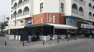 a restaurant in front of a tall building at Livadhiotis City Hotel in Larnaka