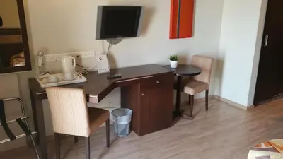 a desk with a computer and two chairs in a room at Livadhiotis City Hotel in Larnaka