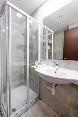 a bathroom with a sink and a shower at Livadhiotis City Hotel in Larnaka