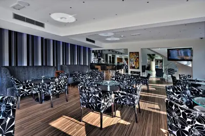 a restaurant with black and white chairs and tables at Livadhiotis City Hotel in Larnaka