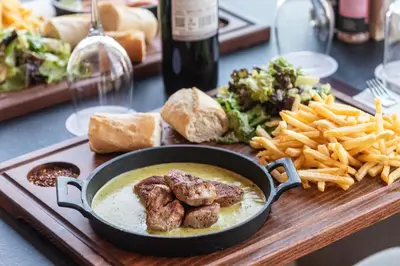 a plate of food with a pan of soup and french fries at Rise Urban Art Hotel in Larnaka