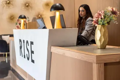 a woman sitting at a desk with a free sign at Rise Urban Art Hotel in Larnaka
