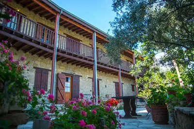 a building with balconies and a courtyard with flowers at Eveleos Country House in Tochni