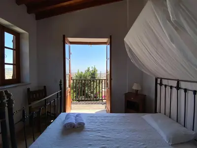 a bedroom with a bed and a door to a balcony at Eveleos Country House in Tochni