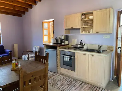 a kitchen with wooden cabinets and a table and a tableablish at Eveleos Country House in Tochni