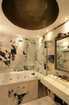 a bathroom with a tub and a sink and a mirror at The Library Hotel Wellness Retreat in Kalavasos