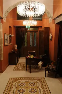 a room with a piano and a chandelier at The Library Hotel Wellness Retreat in Kalavasos