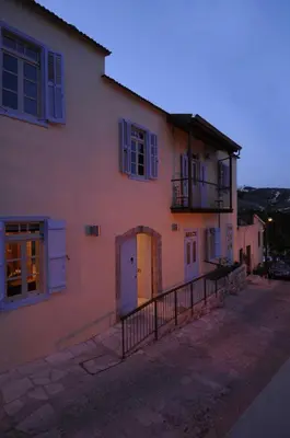 a large white house with blue windows and a balcony at The Library Hotel Wellness Retreat in Kalavasos