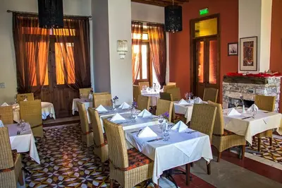 a restaurant with white tables and chairs and a fireplace at The Library Hotel Wellness Retreat in Kalavasos