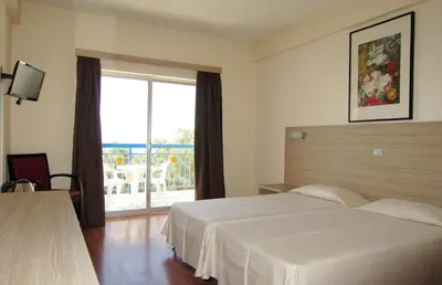 a hotel room with two beds and a large window at Marina Hotel in Ayia Napa