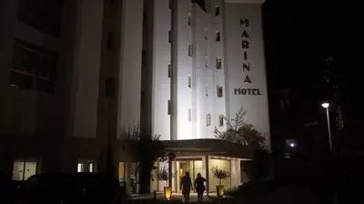 two people walking in front of a hotel at night at Marina Hotel in Ayia Napa