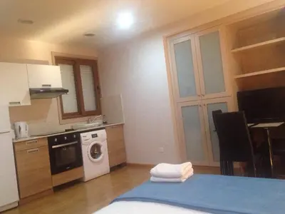 a kitchen with a bed and a washing machine at Les Palmiers Beach Boutique Hotel & Luxury Apartments in Larnaka