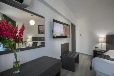 a bedroom with a bed and a vase of red flowers at Blazer Residence in Larnaka