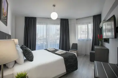 a hotel room with a bed and a large window at Blazer Residence in Larnaka