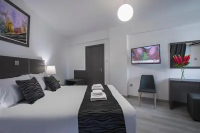 a bedroom with a white bed and a chair at Blazer Residence in Larnaka