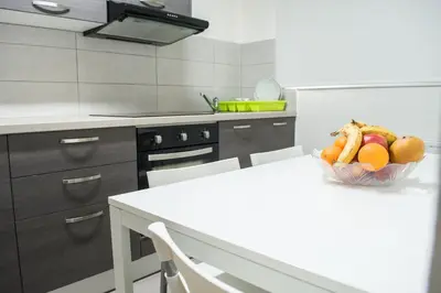 a kitchen with a bowl of fruit on a table at Lordos Hotel Apartments Nicosia in Nicosia