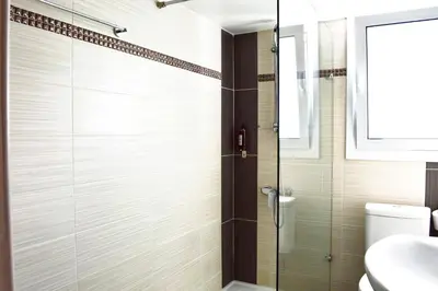 a bathroom with a shower with a glass door at Lordos Hotel Apartments Nicosia in Nicosia