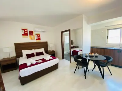 a bedroom with a bed and a table with chairs at Eleonora Hotel Apartments in Larnaka