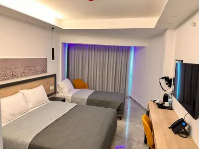 a hotel room with two beds and a flat screen tv at Papouis Protaras Hotel in Protaras