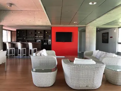a lobby with wicker chairs and a red wall at Allegra GSP Sport Center in Nicosia