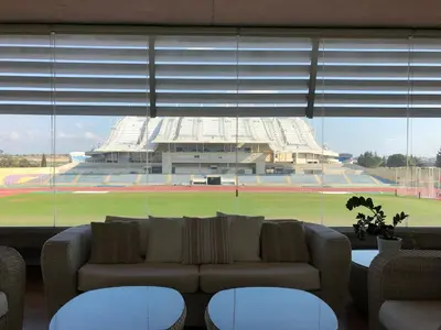 a living room with a couch in front of a stadium at Allegra GSP Sport Center in Nicosia