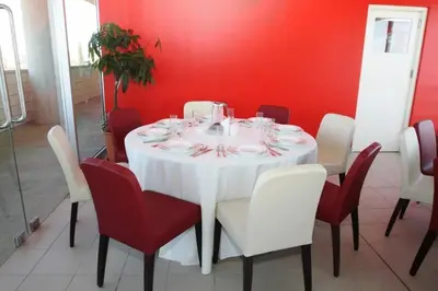 a white table with red chairs and a white table cloth at Allegra GSP Sport Center in Nicosia