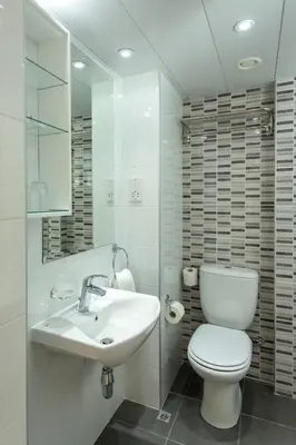 a white bathroom with a toilet and a sink at Kapetanios Bay Hotel Protaras in Protaras